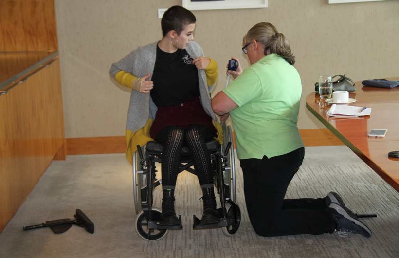 Millie Rose being measured by a Whizz Kidz clinician in her wheelchair