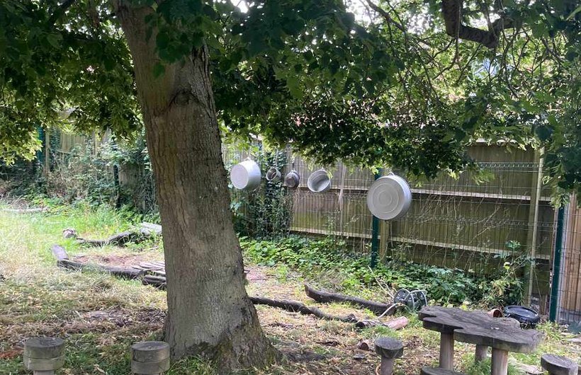 A tree with a small table and benches next to it