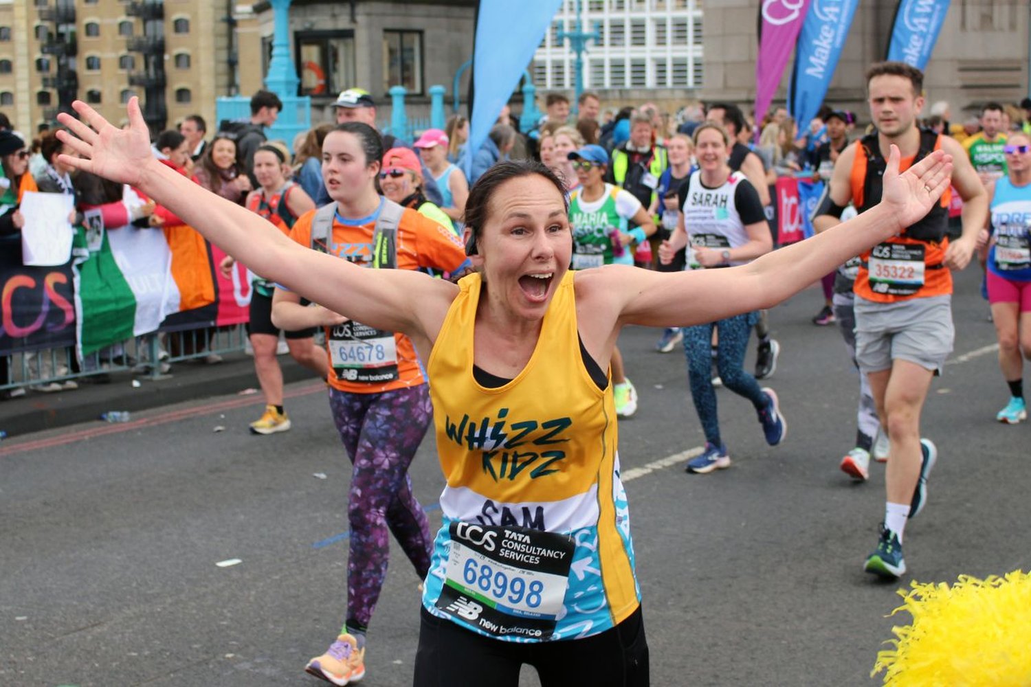 London Marathon charities runner celebrating with Tower Bridge race energy