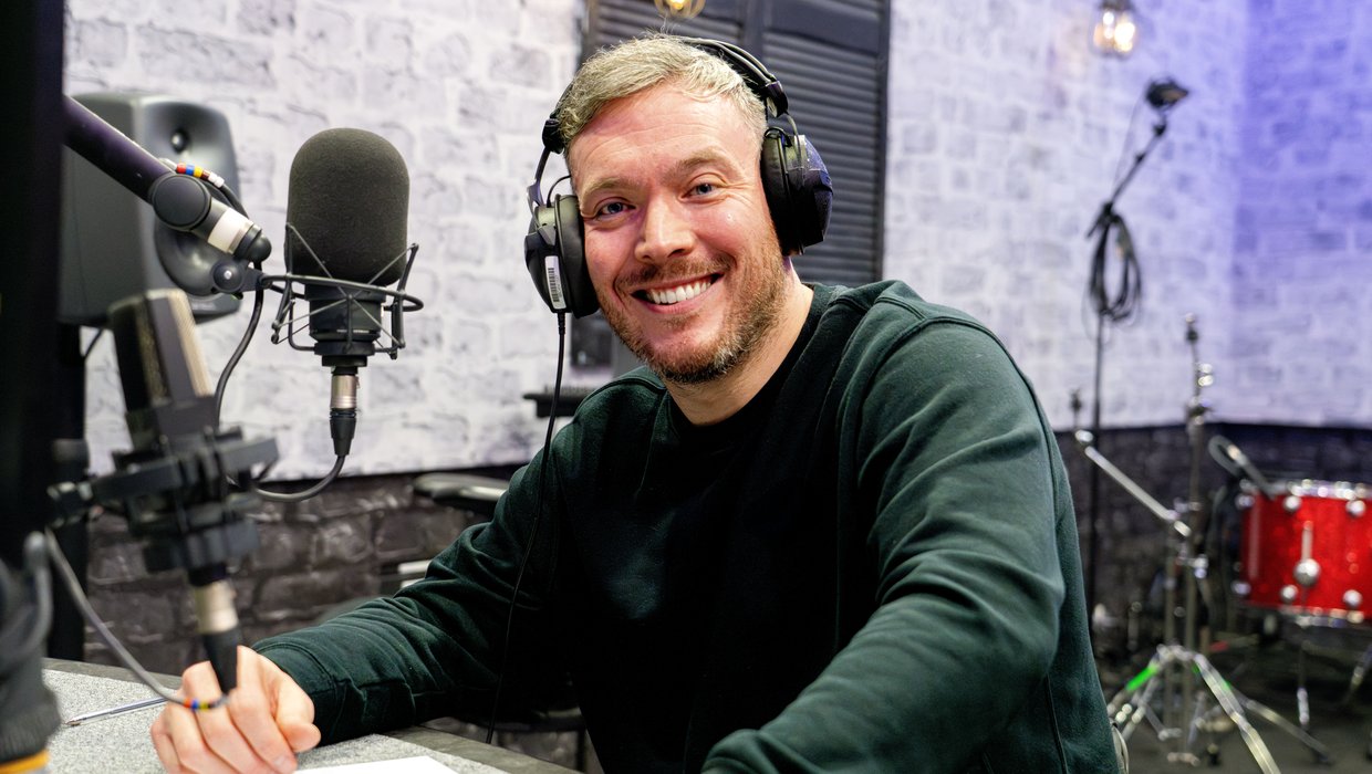 Ambassador Martin Dougan with a microphone in a recording studio recording for BBC Radio 4 Appeal