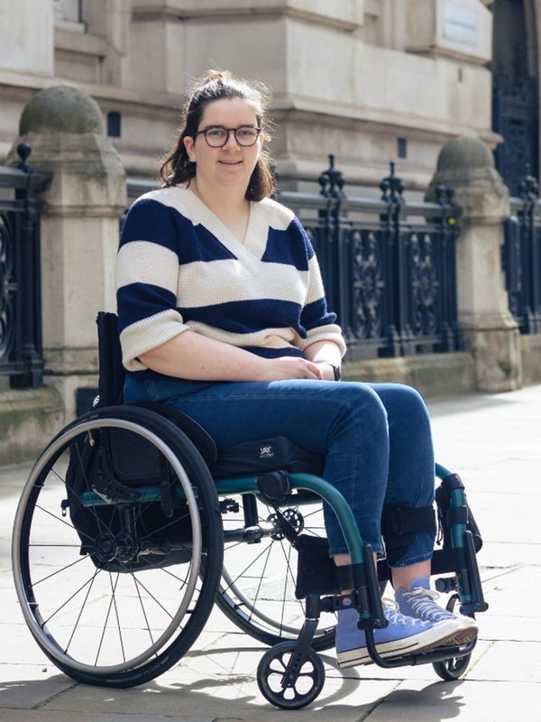 Alice from Kidz Board portrait outside in the street. There is a grand building behind her.