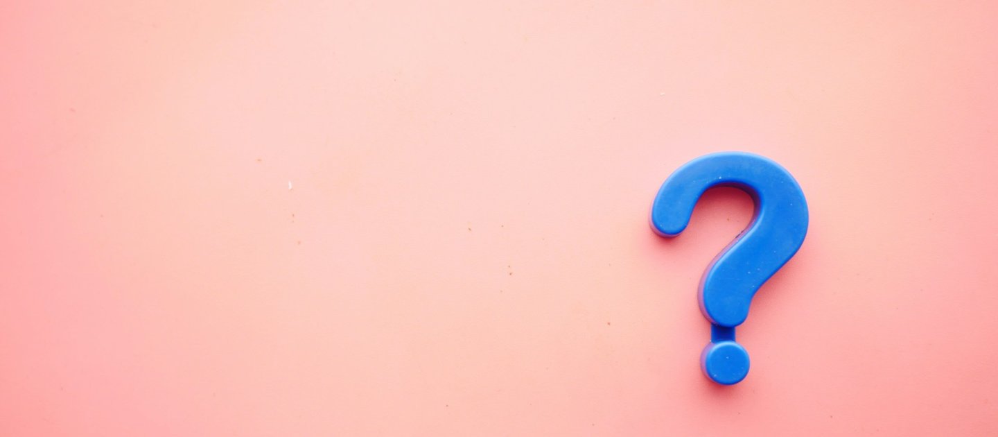 A blue question mark on a pink background