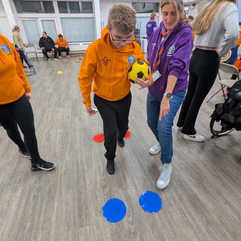 An accessible Scouts Group play together with the help of a Scout Leader