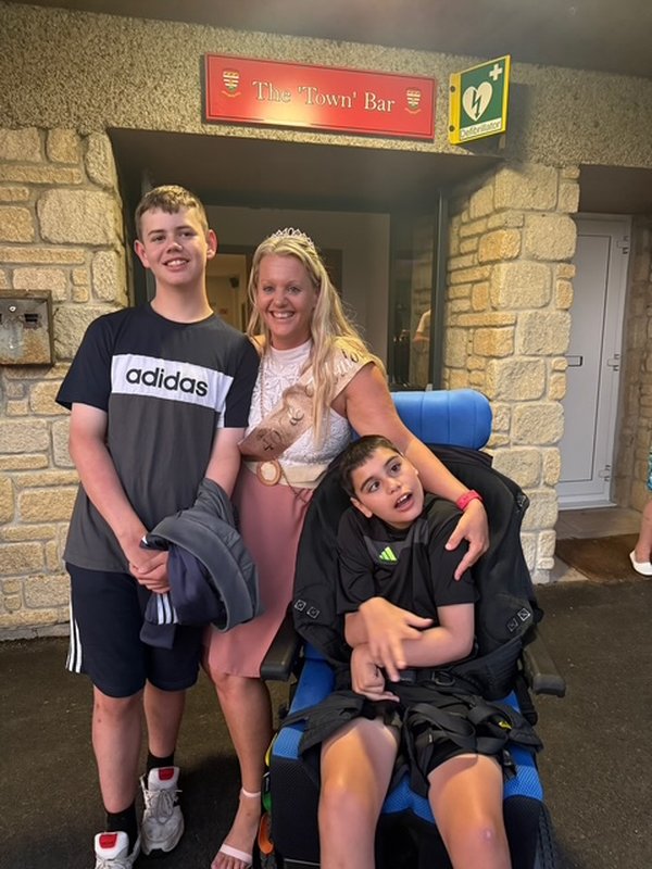 Lesley, a blonde white woman with her two sons, one of whom is Tyler