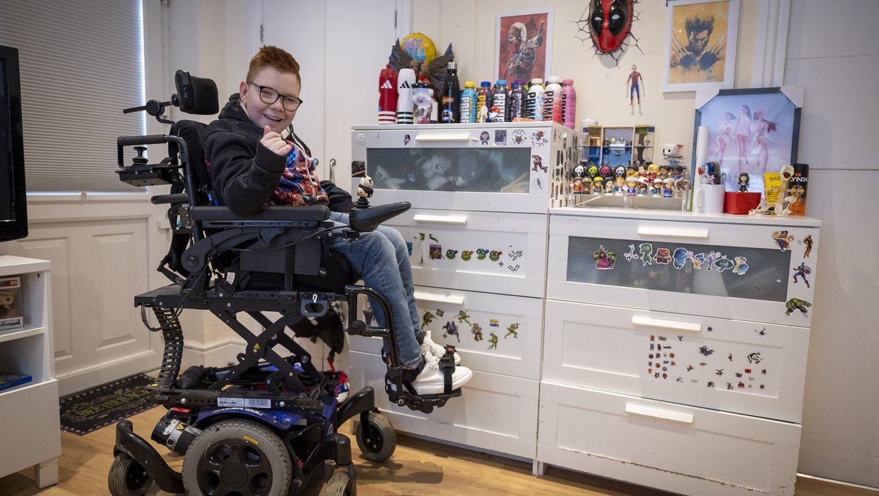 Logan in his bedroom in his powered wheelchair