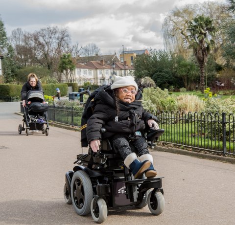 Kiyo-Rei whizzes along a park path in her powered chair