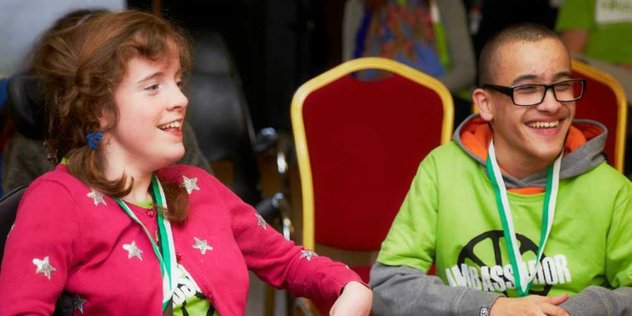 Two young people, sitting and smiling