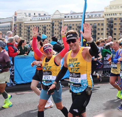 Two runners in yellow Whizz Kidz running vests give us a wave
