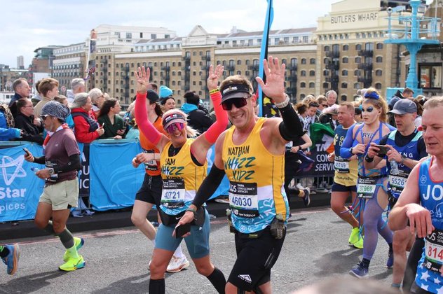 Two runners in yellow Whizz Kidz running vests give us a wave