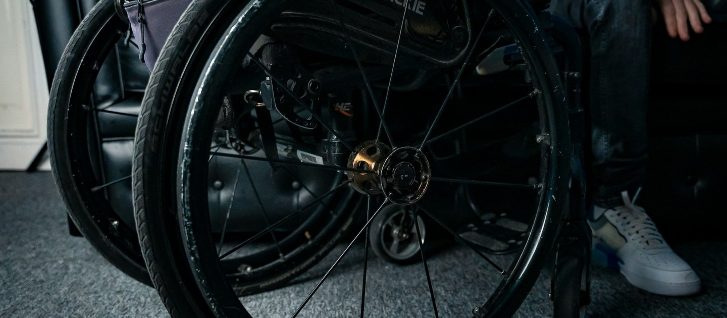 A close up on a black wheelchair wheel
