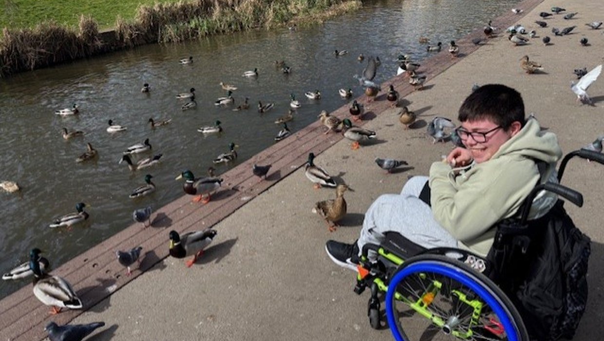 Ollie in his wheelchair feeding Ducks