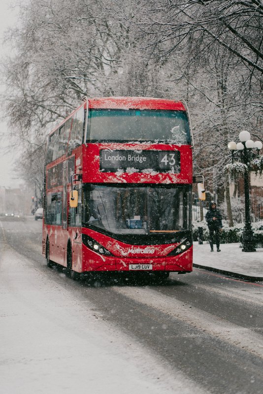 A bus headed for London Bridge driving down a snowy road
