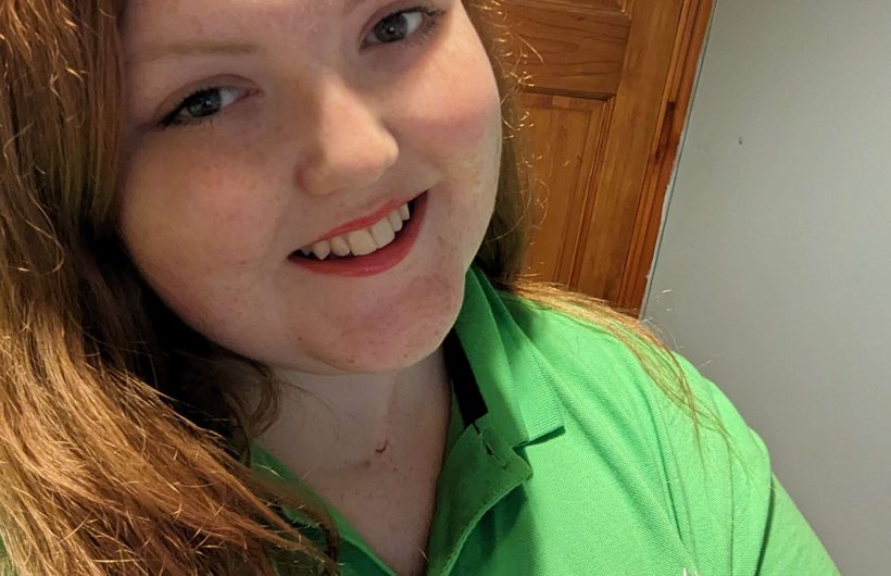 Sophie, our Whizz Kidz volunteer manager smiling wearing a green Whizz Kidz t-shirt