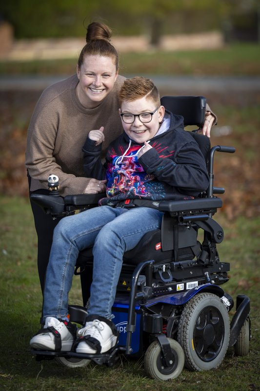 A photo of Logan and his Mum outside
