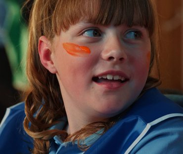 A close up of Amber looking away from the camera. Amber has paint on her face