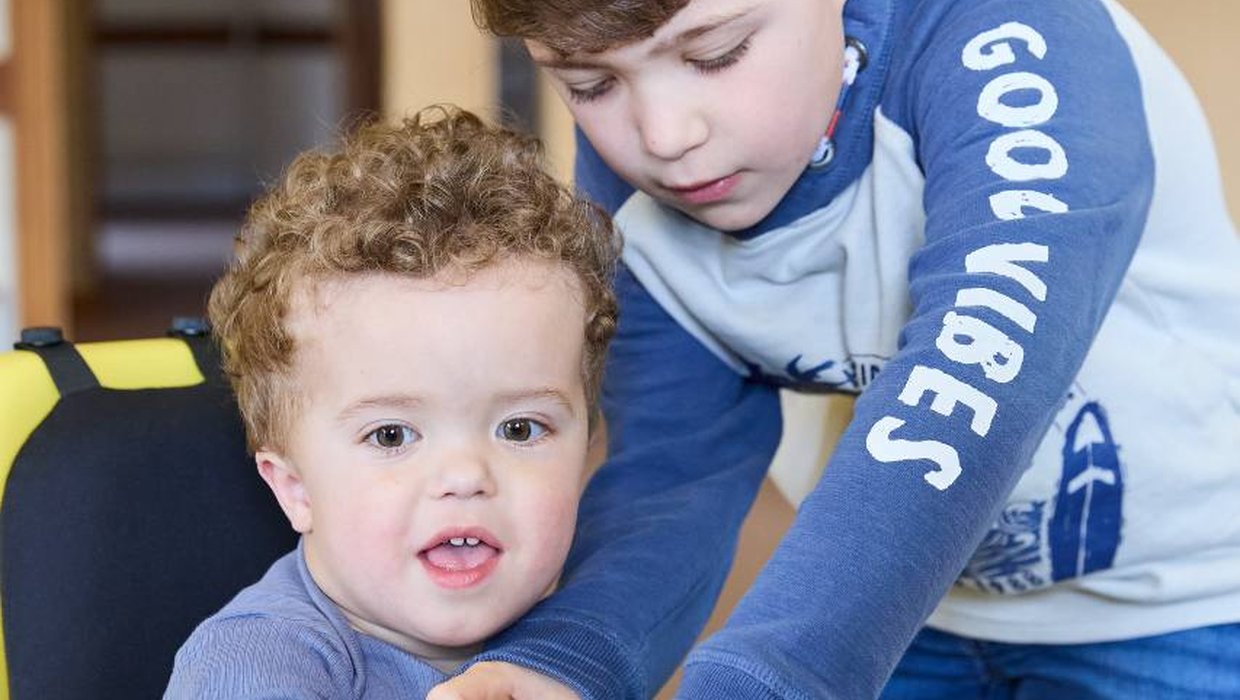 Jake with his older brother Jamie, trying out powered mobility equipment Jake with his older brother Jamie, trying out powered mobility equipment