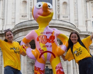 Two Whizz Kidz volunteers stand either side of a Morph sculpture