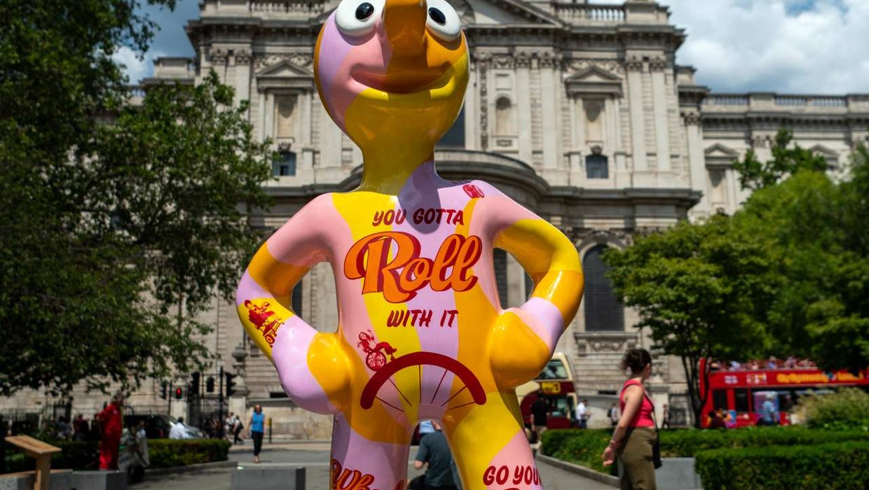Morph with 'Roll with it' written across his front, standing in front of St Pauls
